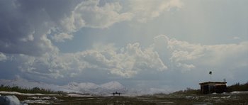 Movie still from “The Big Year” (2011), directed by David Frankel – An airplane is flying in the sky on a cloudy day; Extreme Wide shot, Low angle
