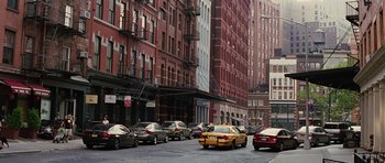 Movie still from “The Big Year” (2011), directed by David Frankel – A city street filled with lots of traffic and parked cars; Extreme Wide shot, High angle