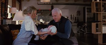 Movie still from “The Big Year” (2011), directed by David Frankel – An older man and woman holding a newborn baby; Medium shot, Over the shoulder angle