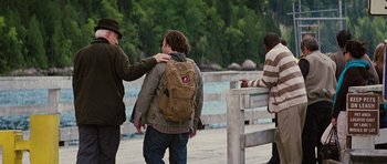 Movie still from “The Big Year” (2011), directed by David Frankel – A man with a backpack is standing next to two other men; Medium shot, Over the shoulder angle