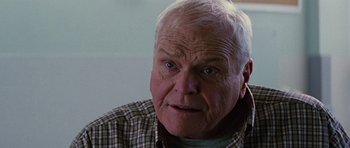 Movie still from “The Big Year” (2011), directed by David Frankel – An older man with a white beard and blue eyes looking at the camera; Close Up shot, Over the shoulder angle
