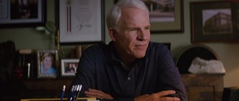 Movie still from “The Big Year” (2011), directed by David Frankel – An older man sitting at a table with his arms crossed; Close Up shot, Over the shoulder angle