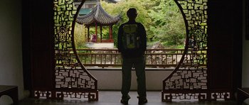 Movie still from “The Big Year” (2011), directed by David Frankel – A man standing in front of an oriental pavilion; Wide shot, Over the shoulder angle