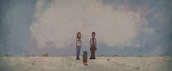 Movie still from “The Biggest Little Farm” (2018), directed by John Chester – A man and a woman standing in front of a plant; Wide shot, Low angle