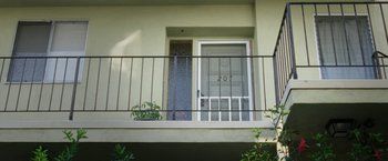 Movie still from “The Biggest Little Farm” (2018), directed by John Chester – A balcony with a metal railing next to a door; Wide shot, Low angle