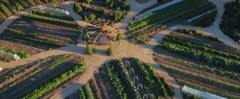 Movie still from “The Biggest Little Farm” (2018), directed by John Chester – An aerial view of an open field with many different plants; Extreme Wide shot, Overhead angle