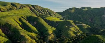 Movie still from “The Biggest Little Farm” (2018), directed by John Chester – A view of a lush green hillside in the mountains; Extreme Wide shot, High angle