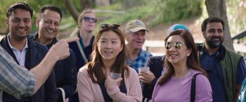 Movie still from “The Biggest Little Farm” (2018), directed by John Chester – A group of people standing next to each other holding drinks; Medium shot, Over the shoulder angle