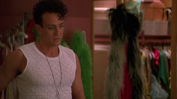 Movie still from “The Birdcage” (1996), directed by Mike Nichols – A man in a white shirt is standing in front of a mirror; Medium shot, Over the shoulder angle