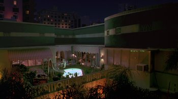 Movie still from “The Birdcage” (1996), directed by Mike Nichols – An outdoor swimming pool at night with a view of the city; Extreme Wide shot, High angle