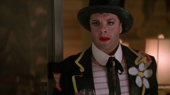 Movie still from “The Birdcage” (1996), directed by Mike Nichols – A person wearing a top hat holding a wine glass; Close Up shot, Over the shoulder angle