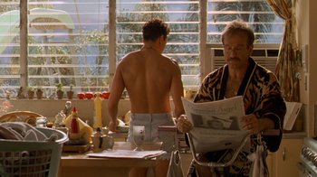 Movie still from “The Birdcage” (1996), directed by Mike Nichols – A man sitting at a table with a man standing next to him; Medium shot, Over the shoulder angle