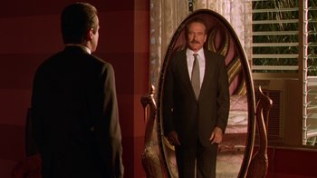 Movie still from “The Birdcage” (1996), directed by Mike Nichols – A man standing in front of a mirror looking at himself in the mirror; Medium shot, Over the shoulder angle