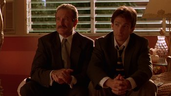 Movie still from “The Birdcage” (1996), directed by Mike Nichols – A couple of men sitting next to each other on top of a bench; Medium shot, Low angle