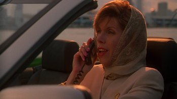Movie still from “The Birdcage” (1996), directed by Mike Nichols – A woman talking on a cell phone while sitting in the back of a car; Close Up shot, Low angle