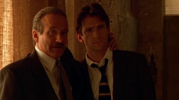 Movie still from “The Birdcage” (1996), directed by Mike Nichols – Two men standing next to each other wearing suits; Close Up shot, Low angle