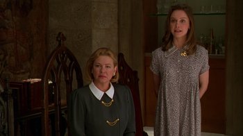 Movie still from “The Birdcage” (1996), directed by Mike Nichols – Two women standing next to each other in front of a wall; Medium shot, Over the shoulder angle