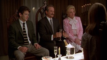 Movie still from “The Birdcage” (1996), directed by Mike Nichols – A group of people sitting around a table with wine glasses; Medium shot, High angle