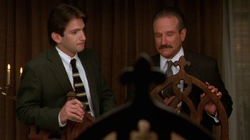 Movie still from “The Birdcage” (1996), directed by Mike Nichols – Two men in suits and ties sitting next to each other; Medium shot, Over the shoulder angle