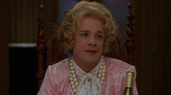 Movie still from “The Birdcage” (1996), directed by Mike Nichols – A woman with blonde hair and a pink dress; Close Up shot, Over the shoulder angle