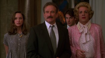 Movie still from “The Birdcage” (1996), directed by Mike Nichols – A group of people standing next to each other in a room; Medium shot, Over the shoulder angle