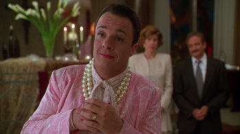 Movie still from “The Birdcage” (1996), directed by Mike Nichols – A man in a pink suit with a pearl necklace and a woman in a white suit; Close Up shot, Over the shoulder angle