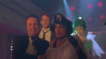 Movie still from “The Birdcage” (1996), directed by Mike Nichols – A group of people standing in front of a stage; Medium shot, Low angle