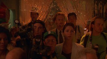 Movie still from “The Birdcage” (1996), directed by Mike Nichols – A group of men and women standing in front of a camera; Close Up shot, Over the shoulder angle