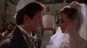 Movie still from “The Birdcage” (1996), directed by Mike Nichols – A man and a woman in wedding attire looking at one another; Close Up shot, Over the shoulder angle