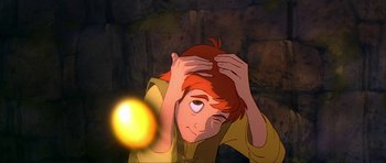 Movie still from “The Black Cauldron” (1985), directed by Ted Berman – A cartoon of a person holding their head in front of a light bulb; Close Up shot, Low angle