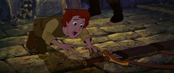 Movie still from “The Black Cauldron” (1985), directed by Ted Berman – A cartoon picture of a boy laying on the ground; Medium shot, Overhead angle