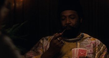 Movie still from “The Black Stallion” (1979), directed by Carroll Ballard – A man smoking a pipe while holding a deck of playing cards; Close Up shot, Over the shoulder angle