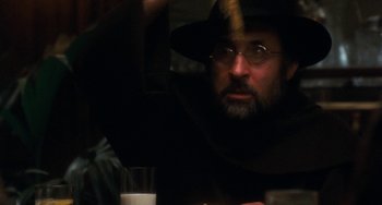 Movie still from “The Black Stallion” (1979), directed by Carroll Ballard – A man in a hat and glasses looking at a glass of milk in front of him; Close Up shot, Over the shoulder angle