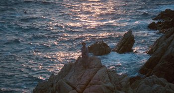 Movie still from “The Black Stallion” (1979), directed by Carroll Ballard – A man sitting on a rock in the middle of the ocean; Extreme Wide shot, High angle
