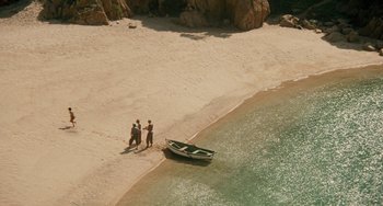 Movie still from “The Black Stallion” (1979), directed by Carroll Ballard – Three people walking on the beach near a boat on the water; Extreme Wide shot, High angle