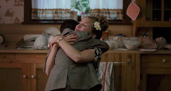 Movie still from “The Black Stallion” (1979), directed by Carroll Ballard – Two people hugging in a kitchen with a window in the background; Medium shot, Over the shoulder angle
