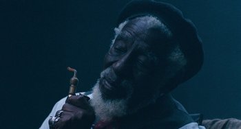 Movie still from “The Black Stallion” (1979), directed by Carroll Ballard – An older man smoking a pipe in a dark room; Extreme Close Up shot, High angle