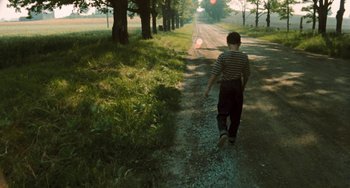 Movie still from “The Black Stallion” (1979), directed by Carroll Ballard – A young boy walking down a dirt road; Wide shot, High angle