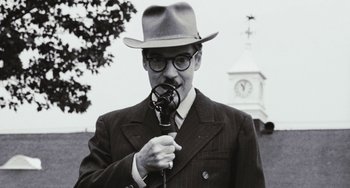Movie still from “The Black Stallion” (1979), directed by Carroll Ballard – A black and white photo of a man in a suit and a hat; Close Up shot, Low angle