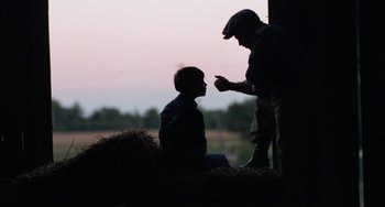 Movie still from “The Black Stallion” (1979), directed by Carroll Ballard – A man and a boy are talking to each other; Medium shot, Over the shoulder angle