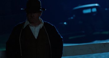 Movie still from “The Black Stallion” (1979), directed by Carroll Ballard – A man wearing a hat standing in the dark; Medium shot, Over the shoulder angle