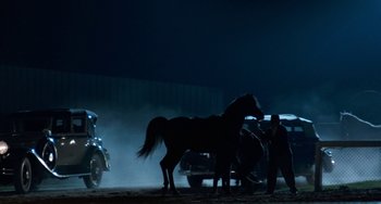 Movie still from “The Black Stallion” (1979), directed by Carroll Ballard – A man standing next to a horse in the dark; Wide shot, Low angle