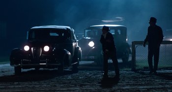 Movie still from “The Black Stallion” (1979), directed by Carroll Ballard – A man standing in the middle of a street at night; Wide shot, Over the shoulder angle