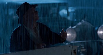 Movie still from “The Black Stallion” (1979), directed by Carroll Ballard – A man in the rain pointing to the sky; Medium shot, Low angle