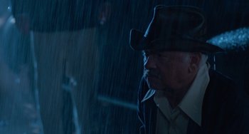 Movie still from “The Black Stallion” (1979), directed by Carroll Ballard – An old man wearing a hat in the rain; Medium shot, Low angle