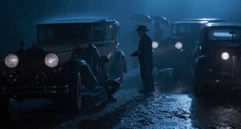 Movie still from “The Black Stallion” (1979), directed by Carroll Ballard – A group of men standing next to an antique car; Wide shot, High angle