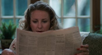Movie still from “The Black Stallion” (1979), directed by Carroll Ballard – A woman is reading a newspaper in a room; Close Up shot, Over the shoulder angle