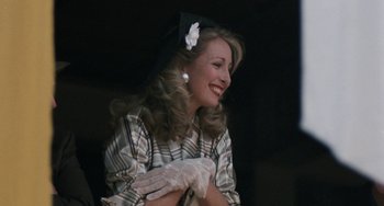 Movie still from “The Black Stallion” (1979), directed by Carroll Ballard – A woman in a hat and gloves smiling; Close Up shot, Over the shoulder angle