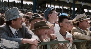 Movie still from “The Black Stallion” (1979), directed by Carroll Ballard – A group of people sitting on top of a metal fence; Close Up shot, High angle