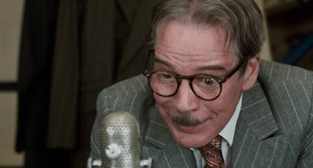 Movie still from “The Black Stallion” (1979), directed by Carroll Ballard – An older man in a suit and tie is looking at a microphone; Close Up shot, Low angle